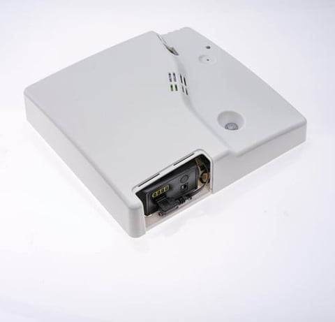 White ceiling-mounted motion sensor and ventilation unit with silver metal connector port on light background