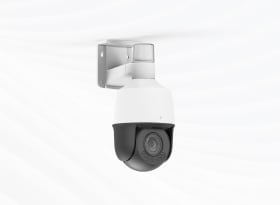 White and black dome security camera mounted on wall bracket with gray housing