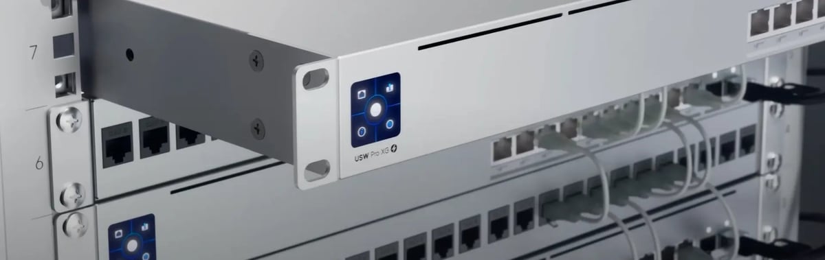Stacked network servers in a rack with blue indicator lights and multiple ethernet ports